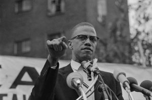 Original Caption: Black Muslim leader Malcolm X, draws various reactions from audience in Harlem rally 6/29. Meeting, at which Malcolm X restated Muslim theme of complete separation of whites and negroes, outdrew a rally sponsored by a civil rights group 10 to 1. This meeting, of the Mississippi-Alabama Southern Relief Committee, was going on at the same time some six blocks away.