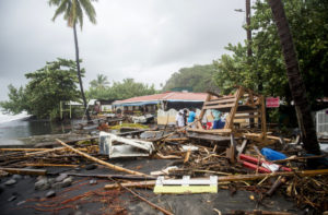 TOPSHOT - People stand next to debris at a restaurant in Le Carbet, on the French Caribbean island of Martinique, after it was hit by Hurricane Maria, on September 19, 2017. Martinique suffered power outages but avoided major damage. / AFP PHOTO / Lionel CHAMOISEAU (Photo credit should read LIONEL CHAMOISEAU/AFP/Getty Images)